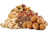 a variety of nuts arranged in a pile including pistashios, walnuts and almonds